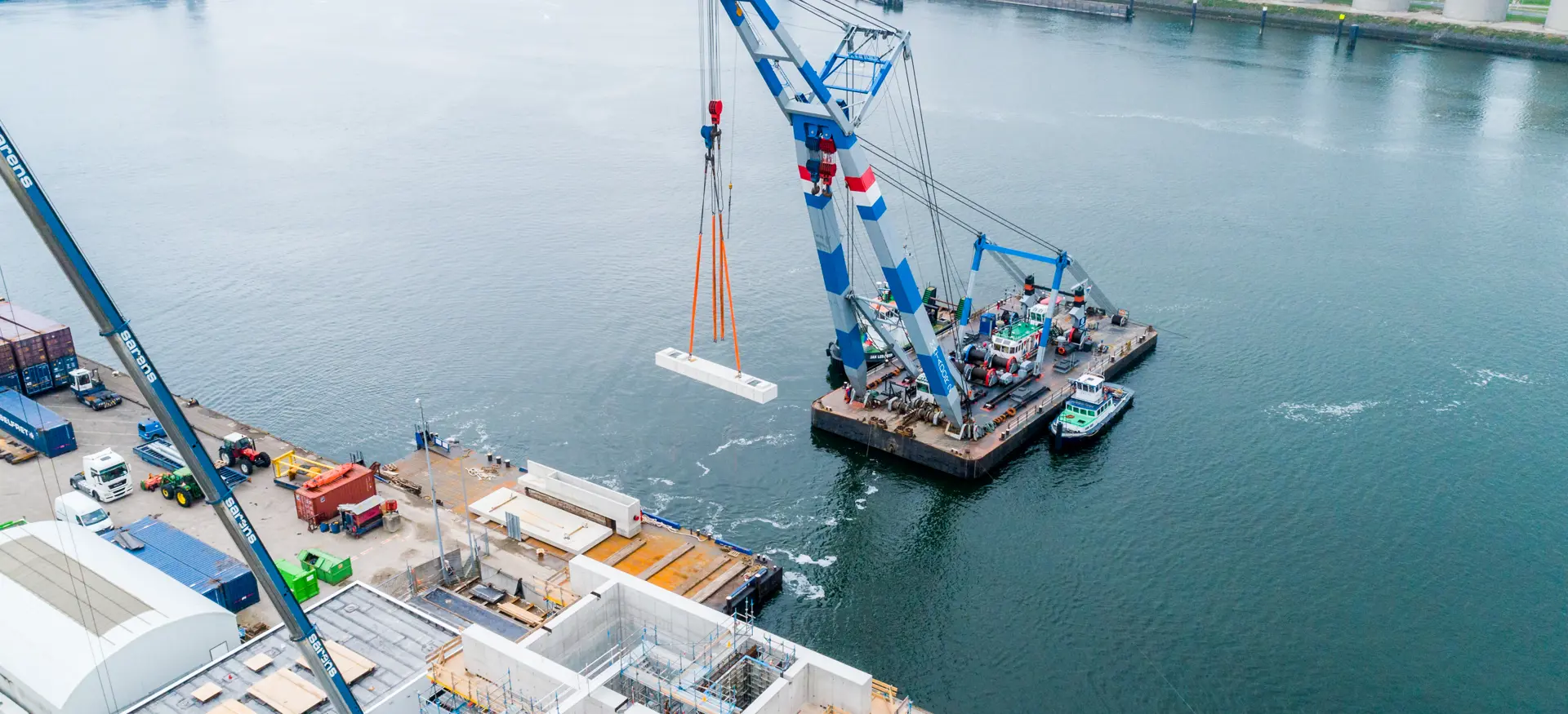 Een drone shot waarbij een gedeelte van het Vopak FireWater Pumphouse op zijn plek wordt gehesen op het water. 